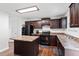 Kitchen featuring dark cabinets, an island, and wood floors at 228 Botanical Ct, Bunnlevel, NC 28323