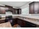 Kitchen area featuring dark cabinets, wood floors, and stainless-steel appliances at 228 Botanical Ct, Bunnlevel, NC 28323