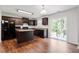 An open kitchen with wood floors, dark cabinets, an island, and stainless-steel appliances at 228 Botanical Ct, Bunnlevel, NC 28323