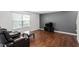 Inviting living room with hardwood floors, neutral paint, large window, and comfortable leather seating at 228 Botanical Ct, Bunnlevel, NC 28323
