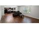 Open-concept living room with hardwood floors, adjoined to kitchen, featuring comfortable leather seating at 228 Botanical Ct, Bunnlevel, NC 28323