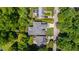 Aerial view of a house showcasing its well-maintained lawn, driveway, and relationship to surrounding lush greenery at 2805 Van Dyke Ave, Raleigh, NC 27607