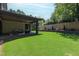 Scenic backyard featuring a covered patio, green lawn, and privacy from mature trees and landscaping at 2805 Van Dyke Ave, Raleigh, NC 27607