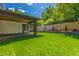 This landscaped backyard includes a lush lawn, brick retaining walls, and mature trees, perfect for outdoor enjoyment at 2805 Van Dyke Ave, Raleigh, NC 27607