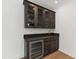 Elegant bar area with a wine fridge, stylish cabinets, granite countertop, and a gold faucet at 2805 Van Dyke Ave, Raleigh, NC 27607