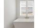 Modern bathroom featuring a freestanding tub with stylish fixtures, framed by a window with plantation shutters at 2805 Van Dyke Ave, Raleigh, NC 27607
