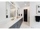 Modern bathroom featuring double vanity, gray cabinets, quartz countertop, gold hardware, and black door at 2805 Van Dyke Ave, Raleigh, NC 27607