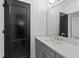 This modern bathroom features a quartz countertop, gray cabinetry, and a large mirror reflecting a bright, clean space at 2805 Van Dyke Ave, Raleigh, NC 27607