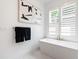 Modern bathroom featuring freestanding tub with gold hardware, white shutters, and contemporary art at 2805 Van Dyke Ave, Raleigh, NC 27607