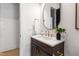 Cozy powder room with wood vanity, gold hardware and accents, and neutral color palette at 2805 Van Dyke Ave, Raleigh, NC 27607