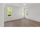 Bright bedroom with hardwood floors, white walls, and abundant natural light from large windows at 2805 Van Dyke Ave, Raleigh, NC 27607