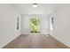 Bright bedroom with hardwood floors and a large window with a view of trees at 2805 Van Dyke Ave, Raleigh, NC 27607