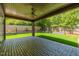 Covered patio with brick flooring, ceiling fan and recessed lights, offering a relaxing view of the lush backyard at 2805 Van Dyke Ave, Raleigh, NC 27607