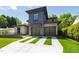 Contemporary home featuring a stylish facade, two-car garage with glass doors, and a well-manicured lawn with striped driveway at 2805 Van Dyke Ave, Raleigh, NC 27607