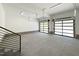 Spacious garage with two modern glass panel doors, bright lighting, and stairs leading to upper level at 2805 Van Dyke Ave, Raleigh, NC 27607
