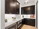 This kitchen has dark cabinets, light countertops, stainless steel microwave and under cabinet lighting at 2805 Van Dyke Ave, Raleigh, NC 27607