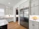 This kitchen boasts stainless steel appliances, white cabinets with brass pulls, and light countertops at 2805 Van Dyke Ave, Raleigh, NC 27607