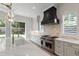 Gourmet kitchen with white cabinets, stainless appliances, a central island with pendant lighting and natural light at 2805 Van Dyke Ave, Raleigh, NC 27607