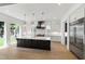 Gourmet kitchen with white cabinets, stainless appliances, a central island with pendant lighting and natural light at 2805 Van Dyke Ave, Raleigh, NC 27607