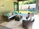 Outdoor covered patio with comfortable seating, decorative pillows, rug and view of the landscaped backyard at 2805 Van Dyke Ave, Raleigh, NC 27607
