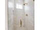 Bright shower featuring white marble tile, gold fixtures, glass door, and mosaic floor at 2805 Van Dyke Ave, Raleigh, NC 27607