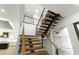 Unique staircase with wood treads, black stringers, and steel cable railings next to the kitchen at 2805 Van Dyke Ave, Raleigh, NC 27607