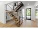 Modern staircase with wood treads, black stringers, and steel cable railings next to a front door at 2805 Van Dyke Ave, Raleigh, NC 27607