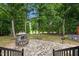 View from deck shows stone patio with an outdoor fireplace and seating area at 3095 Champs Way, Mebane, NC 27302