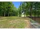 Expansive backyard featuring lush greenery and a pond view with mature trees at 3095 Champs Way, Mebane, NC 27302