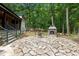 Flagstone patio area shows fireplace with lush trees in the background at 3095 Champs Way, Mebane, NC 27302