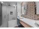 Updated bathroom featuring glass shower, modern sink, and brick accent wall at 3095 Champs Way, Mebane, NC 27302