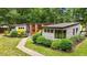 View of home showing gray siding, wood accents, and a stone walkway through manicured landscaping at 3095 Champs Way, Mebane, NC 27302