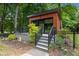 Modern house boasts a deck, black railing, wood facade and landscaping at 3095 Champs Way, Mebane, NC 27302
