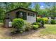 Side view of home shows lush landscaping and a propane tank at 3095 Champs Way, Mebane, NC 27302