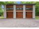 A three-car garage boasting modern design with wood-look doors and contemporary lighting at 3095 Champs Way, Mebane, NC 27302