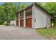 Three-car garage showcasing wood accents, modern lighting, and convenient side access at 3095 Champs Way, Mebane, NC 27302