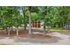 A modern three-car garage blends seamlessly with a wooded, picturesque homesite at 3095 Champs Way, Mebane, NC 27302
