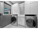 Modern laundry room with black and white floors and stainless appliances at 3095 Champs Way, Mebane, NC 27302