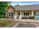 Charming townhome with stone accents, gray roof, and white picket fence offering curb appeal at 320 Madres Ln, Morrisville, NC 27560