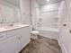 A clean bathroom with white cabinets, quartz countertop, chrome fixtures, and a shower-tub combo at 356 Beacon Hill Rd # 103, Lillington, NC 27546