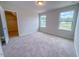 A bright bedroom with neutral walls and carpet, featuring a view from the two windows at 356 Beacon Hill Rd # 103, Lillington, NC 27546