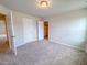 Comfortable bedroom with neutral carpet and walls, open closet, and two entry doors at 356 Beacon Hill Rd # 103, Lillington, NC 27546