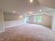 A spacious loft with neutral walls and carpet, featuring a view from the multiple windows at 356 Beacon Hill Rd # 103, Lillington, NC 27546