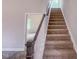 Carpeted staircase leading to upper level featuring natural light from a window at 356 Beacon Hill Rd # 103, Lillington, NC 27546