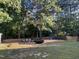 Relaxing backyard space with seating and beautiful landscaping and mature trees at 395 Wyndham Place Dr, Fuquay Varina, NC 27526