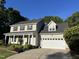 A lovely home featuring a two-car garage, pillared entry, and a landscaped front yard at 395 Wyndham Place Dr, Fuquay Varina, NC 27526