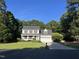 Traditional two-story home with a well-manicured lawn, mature trees, and a long driveway at 395 Wyndham Place Dr, Fuquay Varina, NC 27526