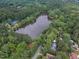 Stunning aerial view of a lake surrounded by lush greenery and a few homes nearby at 4009 Olde Coach Rd, Durham, NC 27707
