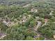 Expansive aerial view of a beautiful neighborhood surrounded by lush trees and a serene lake at 4009 Olde Coach Rd, Durham, NC 27707