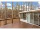 An inviting wooden deck with a railing, leading to a bright sunroom at 4009 Olde Coach Rd, Durham, NC 27707